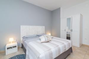 een witte slaapkamer met een groot bed en een tafel bij Loriana seaside home in Santa Teresa Gallura