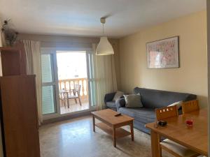 a living room with a couch and a table at Apartamento Portofino Golf & Puerto Almerimar in Almerimar