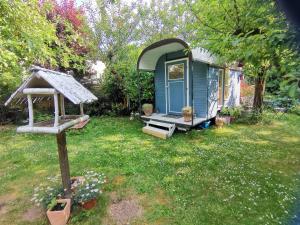 a blue tiny house in a yard with a porch at Schaferwagen in Kassel