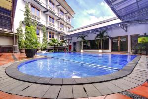 a large swimming pool in the middle of a building at Hotel Bisanta Bidakara Tunjungan in Surabaya