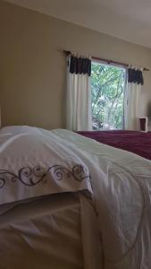 1 cama en un dormitorio con ventana y colcha en Las Watanas en Reyes