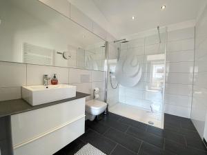 a bathroom with a sink and a toilet and a shower at Staufenresidenz in Oberstaufen +9 photos