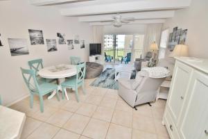 a dining room and living room with a table and chairs at Ocean Club North C208 in New Smyrna Beach