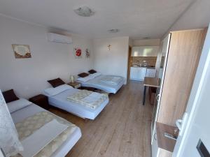 une petite chambre avec deux lits et une cuisine dans l'établissement Pansion Ivan, à Međugorje