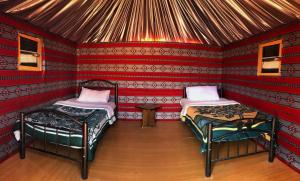 a room with two beds in a red room at joy of life Camp in Wadi Rum