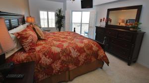 1 dormitorio con 1 cama y vestidor con espejo en Oceanwalk 9-604, en New Smyrna Beach