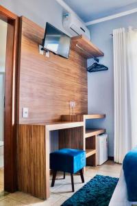 Pokój z biurkiem i telewizorem na ścianie w obiekcie Lara's Hotel w mieście Capitólio