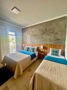 sypialnia z 2 łóżkami i obrazem na ścianie w obiekcie Lara's Hotel w mieście Capitólio