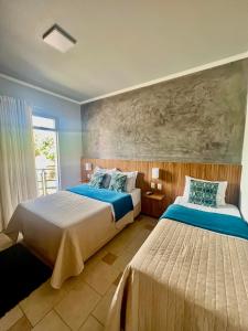ein Schlafzimmer mit zwei Betten und einem Gemälde an der Wand in der Unterkunft Lara's Hotel in Capitólio