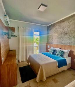 een slaapkamer met een bed met een regenboog op de muur bij Lara's Hotel in Capitólio