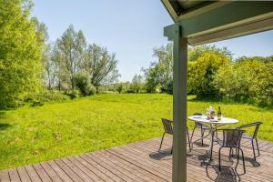 a table and chairs on a deck with a field at The Pump House in Colchester