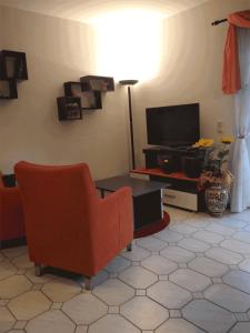 a living room with a chair and a television at Ferienwohnung Pentagono in Engelskirchen
