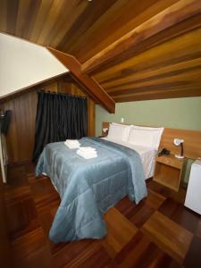 een slaapkamer met een bed en een houten plafond bij Pousada Jordão in Campos do Jordão