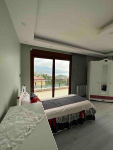 um quarto com uma cama e uma grande janela em The Luxe Esenköy Villa em Yalova