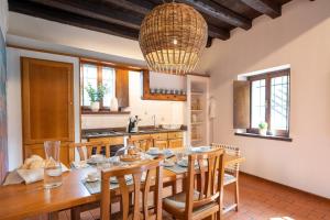 comedor con mesa y sillas en la cocina en Casa Ortensia: rustico ristrutturato in pietra, en Rive dʼArcano