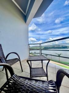 two chairs on a balcony with a view of the water at Lara's Hotel in Capitólio