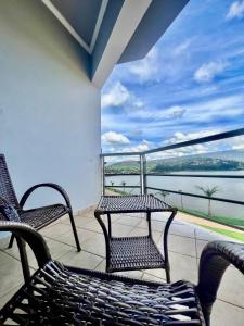 twee stoelen op een balkon met uitzicht op het water bij Lara's Hotel in Capitólio