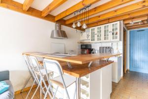 a kitchen with a wooden counter top and white cabinets at Villa Jumelée Proche Des Plages Du in Biscarrosse