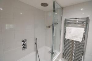 a bathroom with a shower with a glass door at 2 Rose Cottages in St. Agnes 