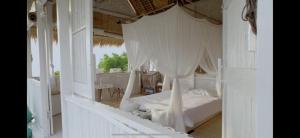 a bedroom with a white bed with a canopy at Ocean Glamping Penida in Nusa Penida