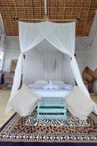Ocean Glamping Penida في نوسا بينيدا: سرير مع مظلة في الغرفة