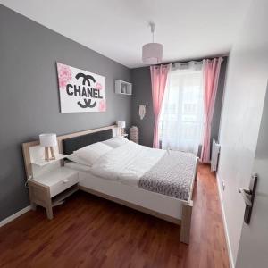 una camera con un letto bianco e una finestra di Appartement Cosy proche Disney a Pontault-Combault