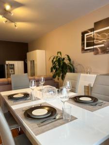 een eettafel met borden en wijnglazen erop bij Appartement Cosy proche Disney in Pontault-Combault