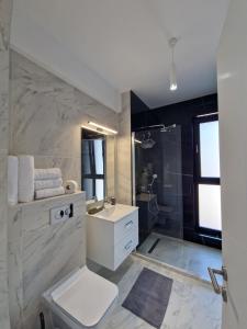 La salle de bains est pourvue de toilettes blanches et d'un lavabo. dans l'établissement Studio Armsea Mamaia Nord, à Mamaia