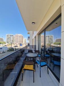 a balcony with tables and chairs on a building at Studio Armsea Mamaia Nord in Mamaia