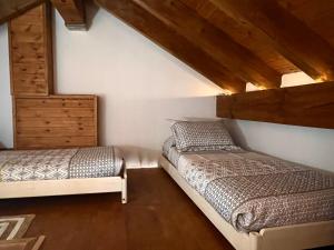 2 camas en una habitación con techos de madera en La Buhardilla de Baro, en Baro