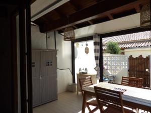a patio with a table and chairs and a door at Bleu Soleil in Gruissan