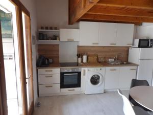 a kitchen with a washing machine and a washer at Bleu Soleil in Gruissan