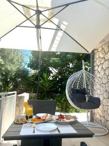 a table with a plate of food and a swing at Sun&Fun Studio Apartment in Hvar