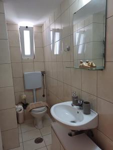 łazienka z umywalką, toaletą i lustrem w obiekcie Maria's Studio No2 in Heraklion w Heraklionie