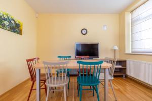 a dining room with a table and chairs and a tv at CAMELIA CENTRE APARTMENT in Palanga