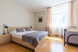 a bedroom with a bed and a large window at CAMELIA CENTRE APARTMENT in Palanga