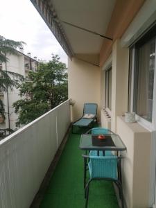 einen Balkon mit 2 Stühlen und einem Tisch auf einem Gebäude in der Unterkunft Appartement des Cygnes in Annecy