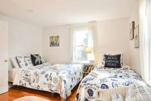 Cette chambre comprend deux lits, un canapé et une fenêtre. dans l'établissement Stunning Bay Views by Beach Dog Friendly, à Eastham