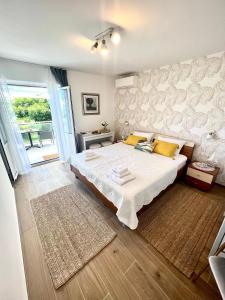 ein Schlafzimmer mit einem großen Bett mit gelben Kissen in der Unterkunft Sun&Fun Studio Apartment in Hvar