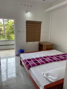 a bedroom with a bed and a table and a window at New star homes in Kotamangalam