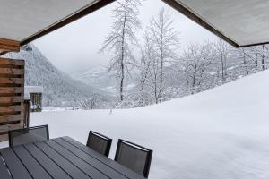a table and chairs in a room with a snow covered yard at Les Loges Blanches - Apt B103 - BO Immobilier in Châtel