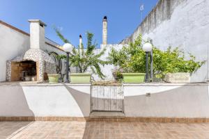 un muro di pietra con un cancello e alcune piante di Casa vacanze vicino a Otranto a Giurdignano