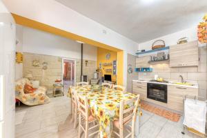 una cucina e una sala da pranzo con tavolo e sedie di Casa vacanze vicino a Otranto a Giurdignano
