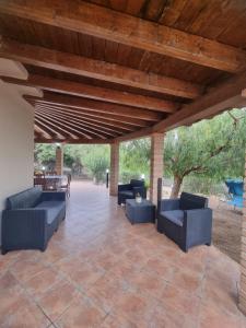 un patio coperto con divani e soffitto in legno di Casa La Rosa Gialla a Solanas