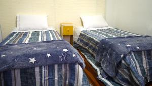 - deux lits assis l'un à côté de l'autre dans une pièce dans l'établissement Casinha, à Porto Alegre