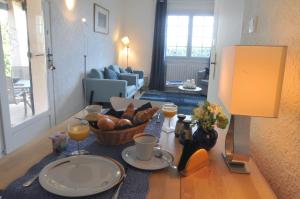 a table with a basket of bread and cups of orange juice at Residence "Villa Catherine" in Flayosc