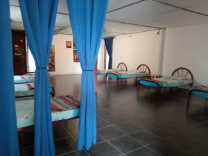 a room with blue curtains and beds in it at MULU BACKPACKER HOMESTAY in Mulu