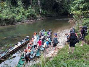 a group of people on boats on a river at MULU BACKPACKER HOMESTAY in Mulu