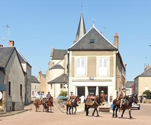 un grupo de gente a caballo caminando por una calle en Relax au Coeur du Morvan, en Ouroux