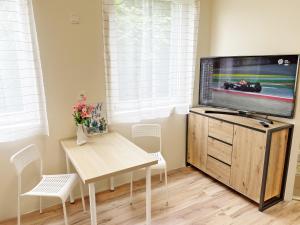 a living room with a television on a wooden stand at Lipták Vendégház in Balatonfüred